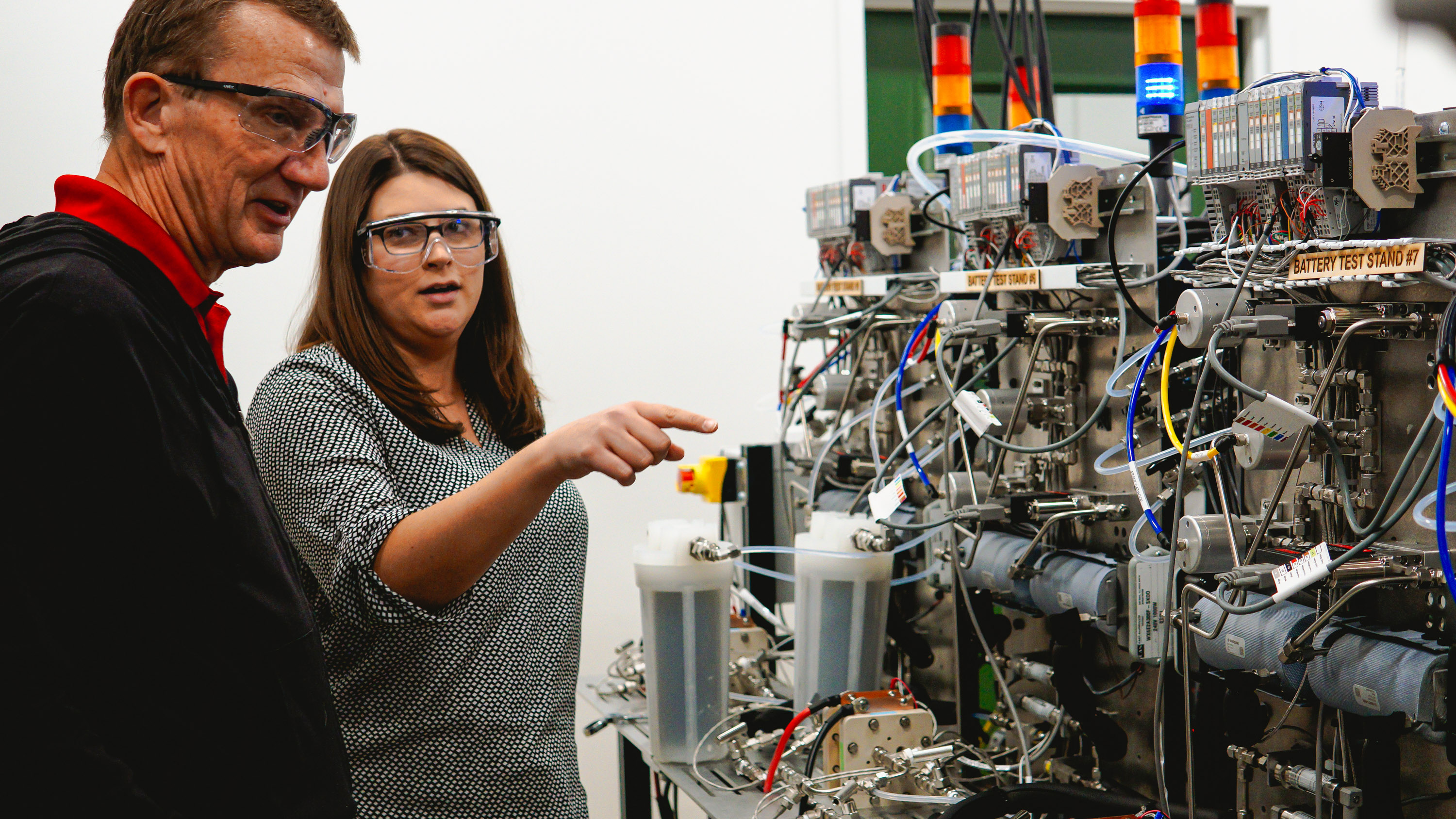 two Electric Hydrogen employees discuss the reactor in front of them